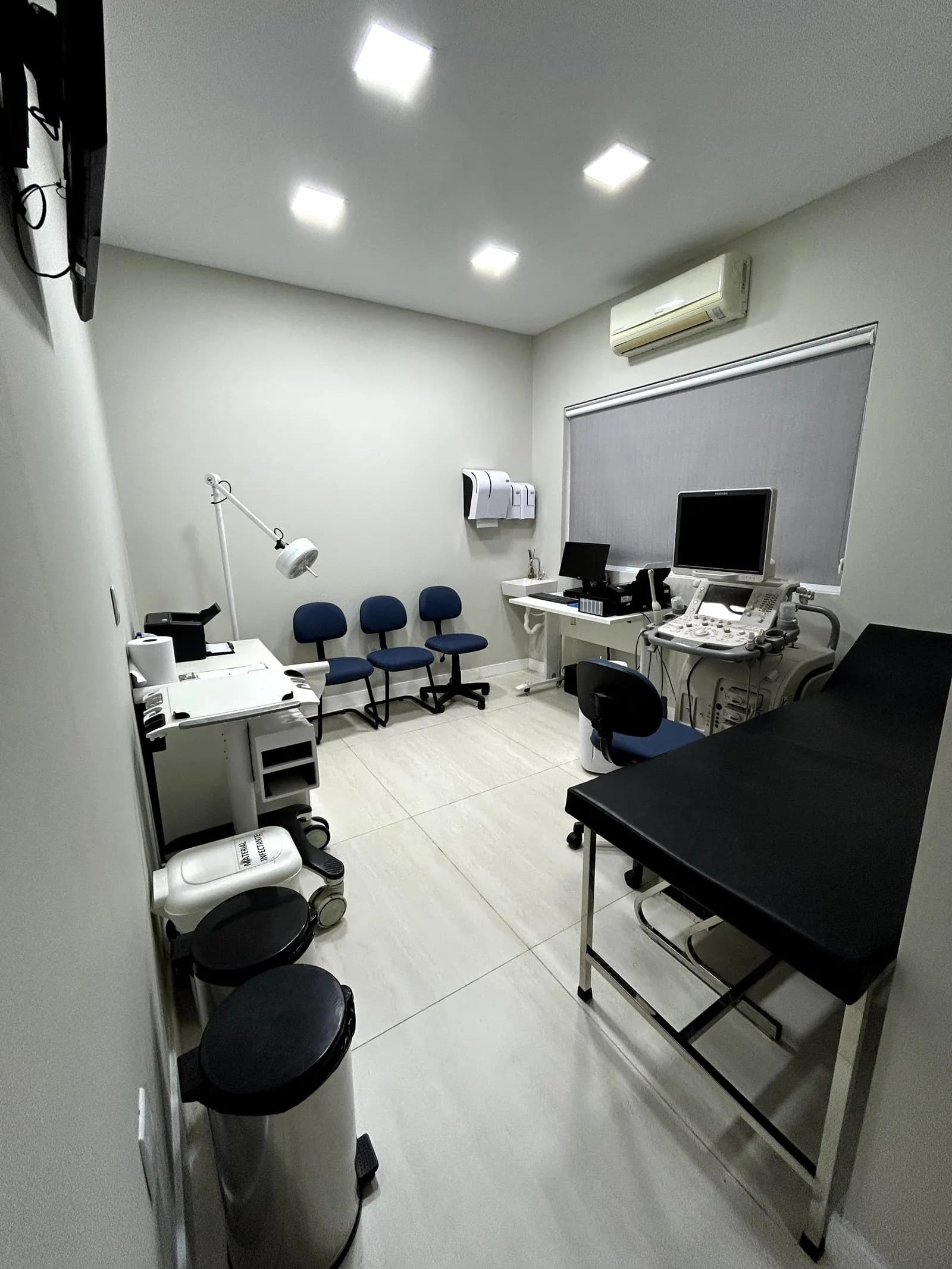 Consultório da Clínica Santoro com maca e equipamento de ultrassom, em fotografia do acervo oficial
